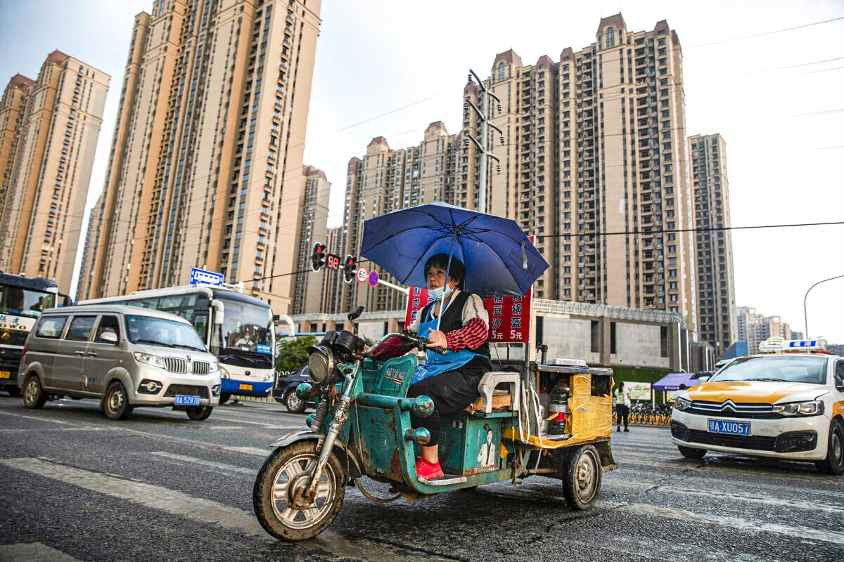 A vendor cycles through the Evergrande changqing community in the rain on Sept. 24, 2021 in Wuhan, Hubei Province, China. ( Getty Images)