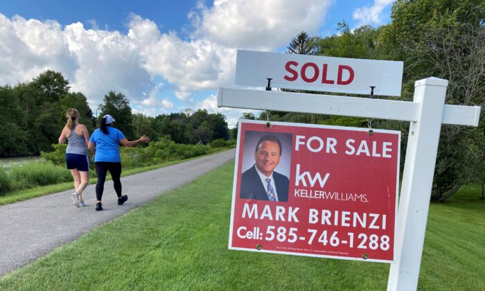 People walk by a sold sign in front of a house along the Erie Canal in Pittsford, N.Y., York, on Sept. 6, 2021. (Ted Shaffrey/AP Photo)