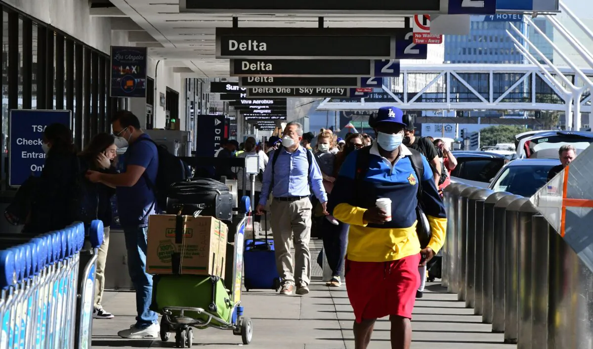 Travelers walk through the airport in Los Angeles, on Nov. 23, 2021. (Frederic J. Brown/AFP via Getty Images)