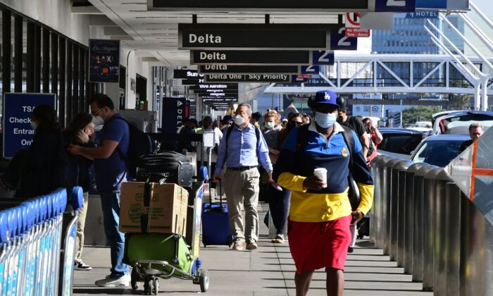 Travelers walk through the airport in Los Angeles, on Nov. 23, 2021. (Frederic J. Brown/AFP via Getty Images)