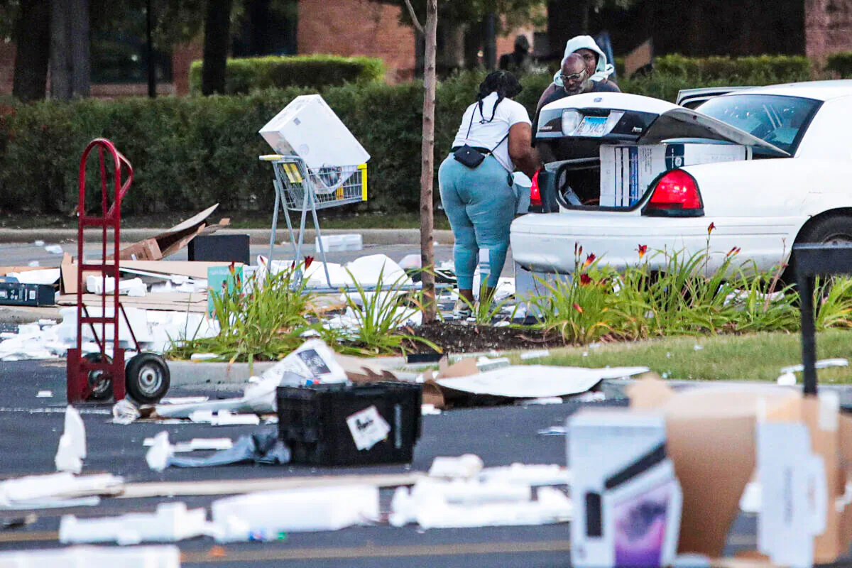 People load merchandise into a car near a looted Best Buystore after parts of the city had widespread looting and vandalism in Chicago on Aug. 10, 2020. Police made several arrests during the night of unrest and recovered at least one firearm. (Scott Olson/Getty Images)
