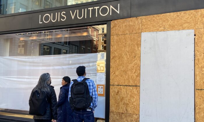 Union Square visitors look at damage to a Louis Vuitton store in San Francisco, Calif., on Nov. 21, 2021. (Danielle Echeverria/San Francisco Chronicle via AP)