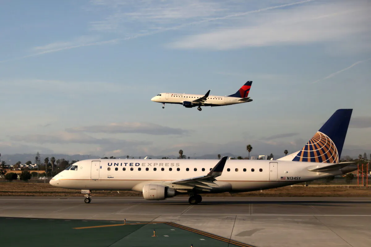 A Delta Connection Embraer ERJ-175LR plane lands as a United Express Embraer ERJ-175LR plane waits to take off at LAX airport in Los Angeles, on Jan. 10, 2018. (Lucy Nicholson/Reuters)