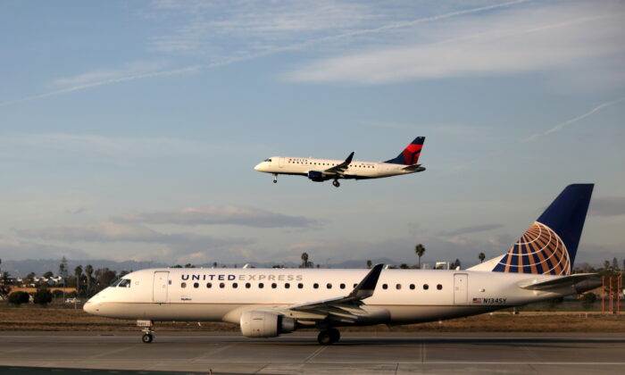 A Delta Connection Embraer ERJ-175LR plane lands as a United Express Embraer ERJ-175LR plane waits to take off at LAX airport in Los Angeles, on Jan. 10, 2018. (Lucy Nicholson/Reuters)