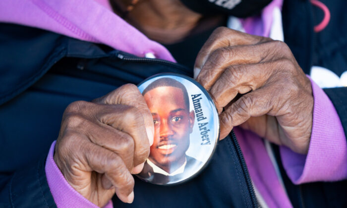 Annie Polite puts on a button for Ahmaud Arbery outside the Glynn County Courthouse as the jury deliberates in the trial of the killers of Ahmaud Arbery on Nov. 24, 2021 in Brunswick, Georgia. (Sean Rayford/Getty Images)
