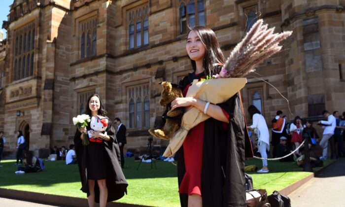Student Zheng Zizan from Xian in China (R) poses for family photos after graduating with a Masters of Commerce from Sydney University on October 12, 2017. (WILLIAM WEST/AFP via Getty Images)