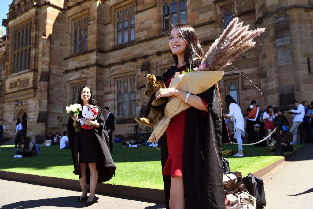 A student from China poses for photos after graduating with from Sydney University on Oct. 12, 2017. (William West/AFP via Getty Images)