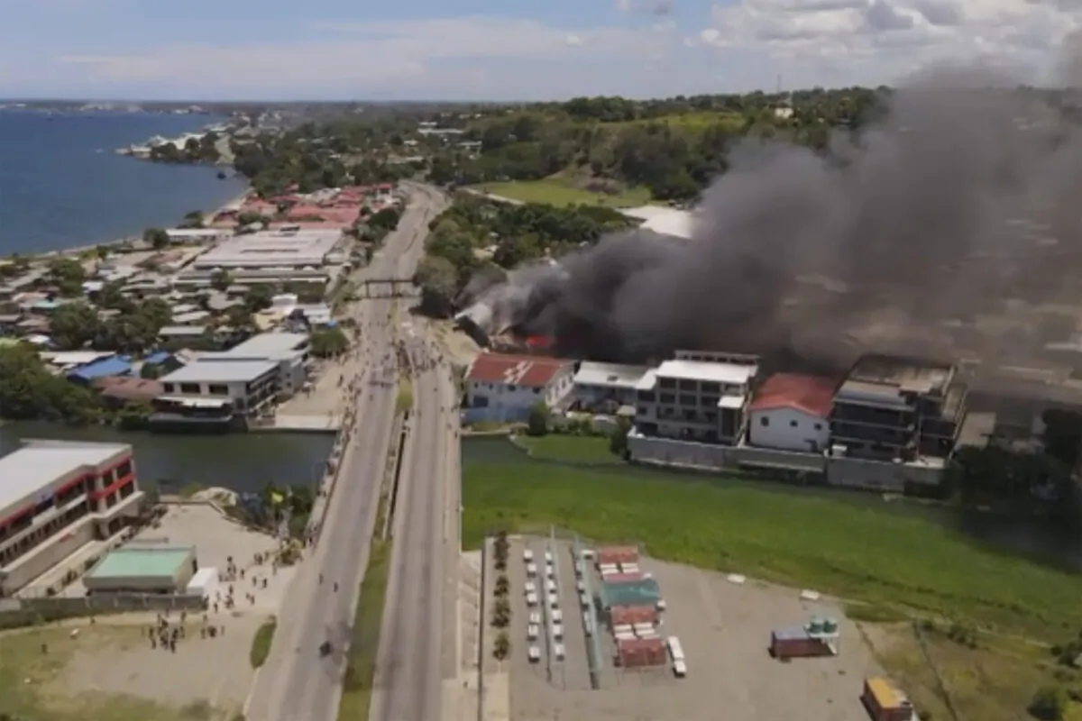 Smoke rises from burning buildings during a protest in the capital of Honiara, Solomon Islands, on Nov. 25, 2021, in this image made from aerial video. (Australian Broadcasting Corporation via AP)