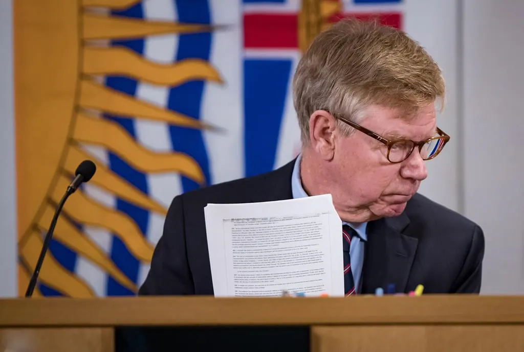 Commissioner Austin Cullen looks at documents before opening statements at the Cullen Commission of Inquiry into Money Laundering in British Columbia, in Vancouver, Feb. 24, 2020. (The Canadian Press/Darryl Dyck)