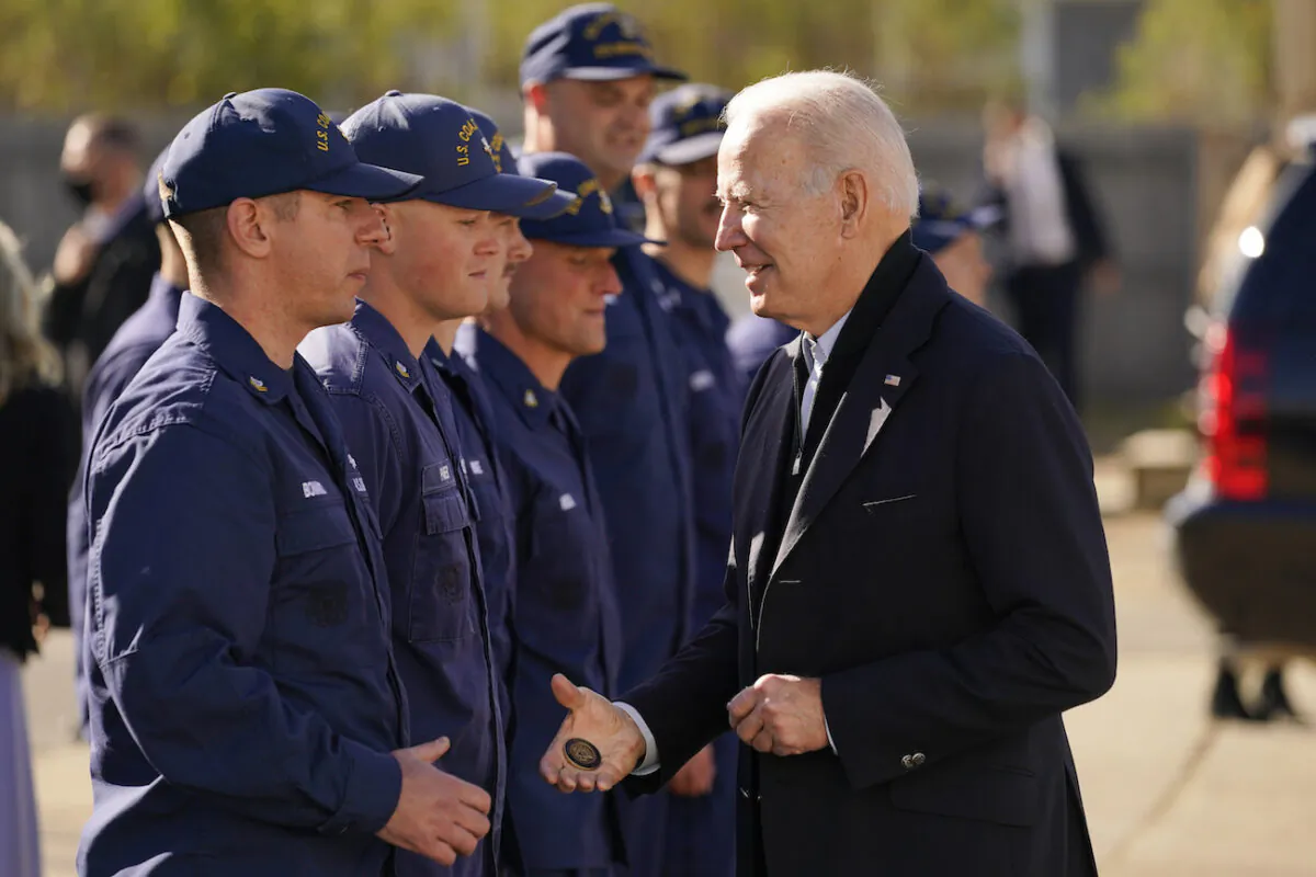 President Joe Biden hands out a challenge coin as he speaks with members of the Coast Guard at the United States Coast Guard Station Brant Point in Nantucket, Mass., on Nov. 25, 2021. (AP Photo/Carolyn Kaster)