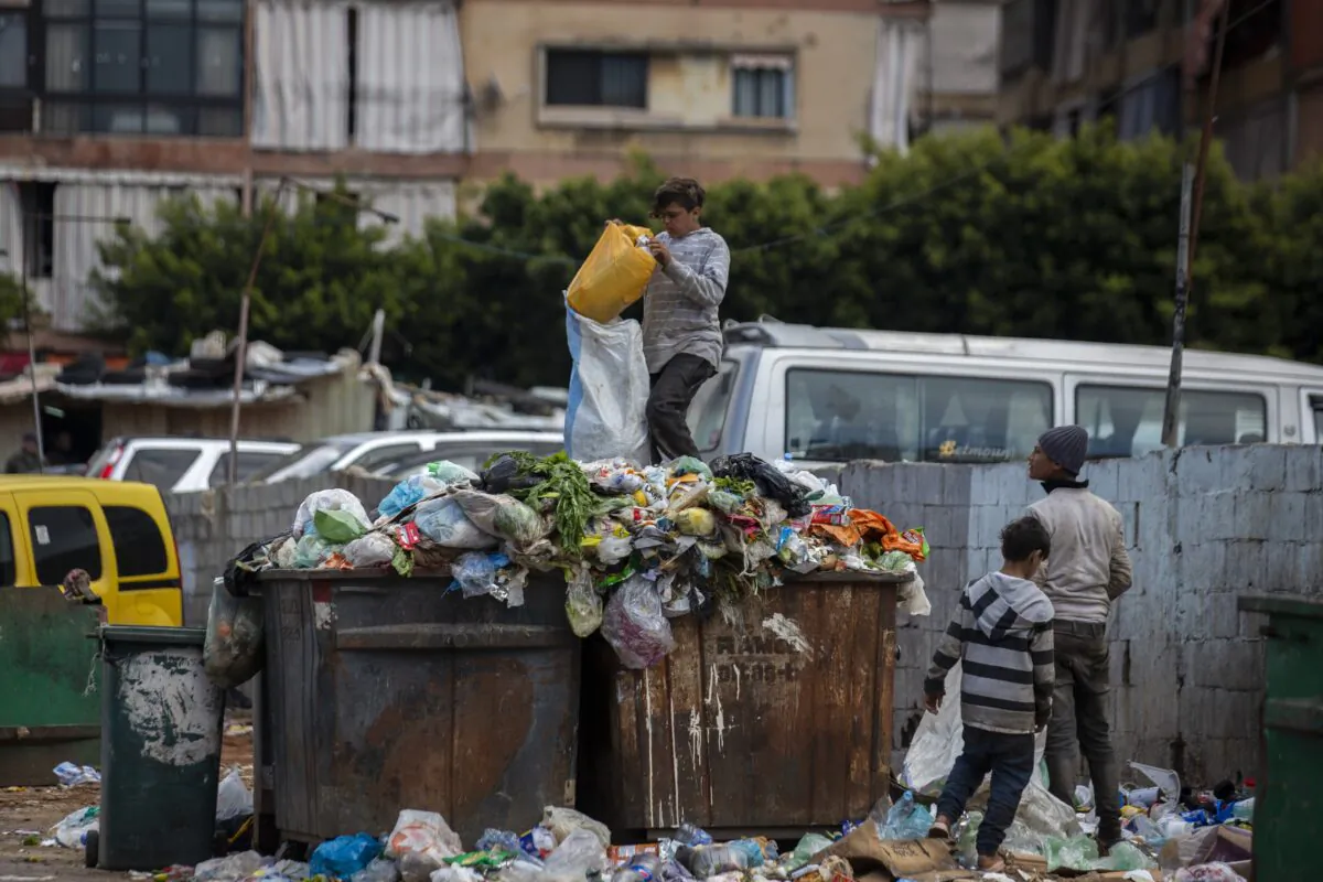 Children search for valuables in the garbage next to a market in Beirut, Lebanon, on April 12, 2021. (Hassan Ammar/AP Photo)