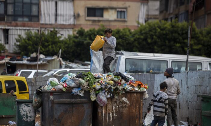 Children search for valuables in the garbage next to a market in Beirut, Lebanon, on April 12, 2021. (Hassan Ammar/AP Photo)