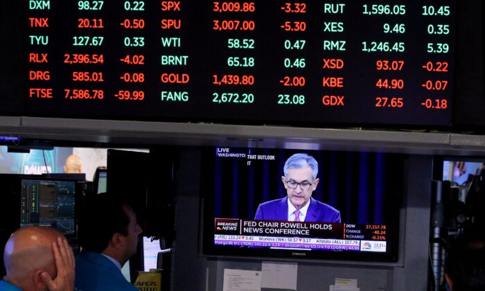 Traders look on as a screen shows Federal Reserve Chairman Jerome Powell's news conference after the Federal Reserve interest rates announcement on the floor of the New York Stock Exchange (NYSE) in New York, on July 31, 2019. (Brendan McDermid/Reuters)
