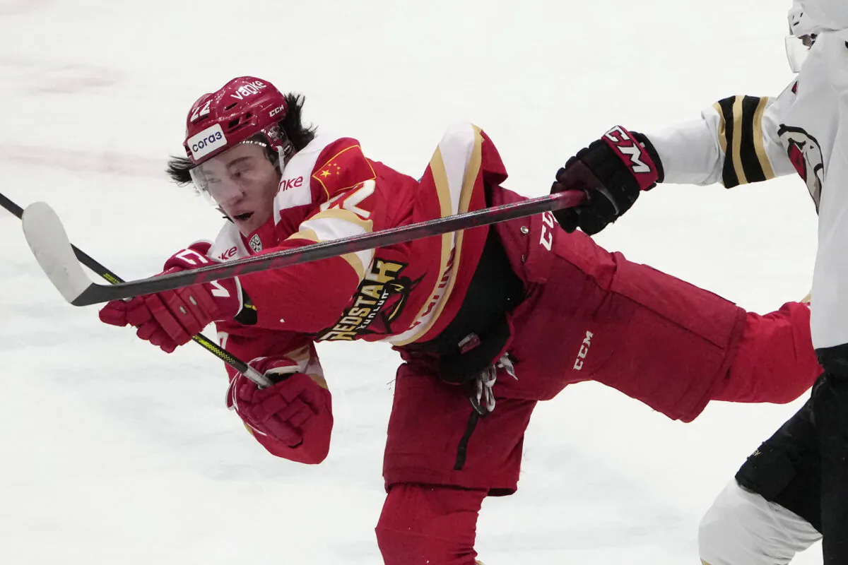 Kunlun Red Star's Parker Foo battles for the puck during the Kontinental Hockey League ice hockey match between Kunlun Red Star Beijing and Avangard Omsk in Mytishchi, outside Moscow, Russia, on Nov. 17, 2021. (Pavel Golovkin/AP Photo)