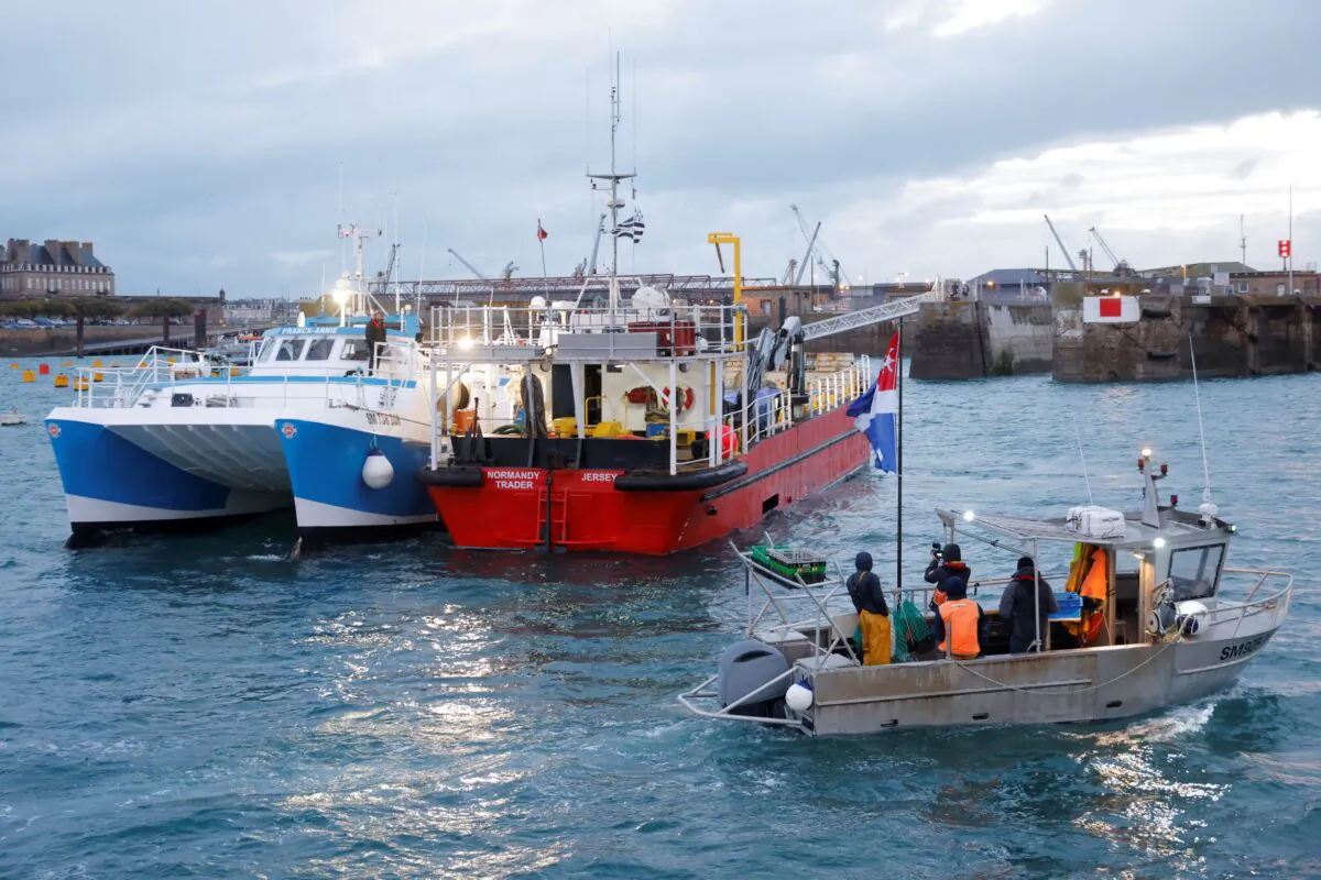 French fishermen block the 'Normandy Trader' boat at the entrance of the port of Saint-Malo as they started a day of protests to mark their anger over the issue of post-Brexit fishing licenses, in Saint-Malo, France, on Nov. 26, 2021. (Stephane Mahe/Reuters)