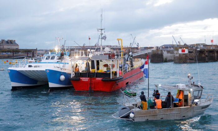 French fishermen block the 'Normandy Trader' boat at the entrance of the port of Saint-Malo as they started a day of protests to mark their anger over the issue of post-Brexit fishing licenses, in Saint-Malo, France, on Nov. 26, 2021. (Stephane Mahe/Reuters)
