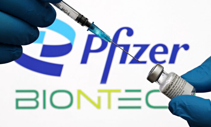 A medical syringe and vials of the Pfizer U.S. pharmaceutical corporation and BioNTech German biotechnology company logos are seen in New York City, on Oct. 3, 2021. (Cindy Ord/Getty Images for Pfizer/BioNTech)