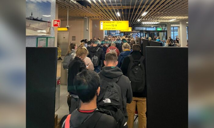 Passengers traveling from South Africa queue to be coronavirus disease (COVID-19) tested after being held on the tarmac at Schiphol Airport, Netherlands, on Nov. 25, 2021. (Social media via Reuters)