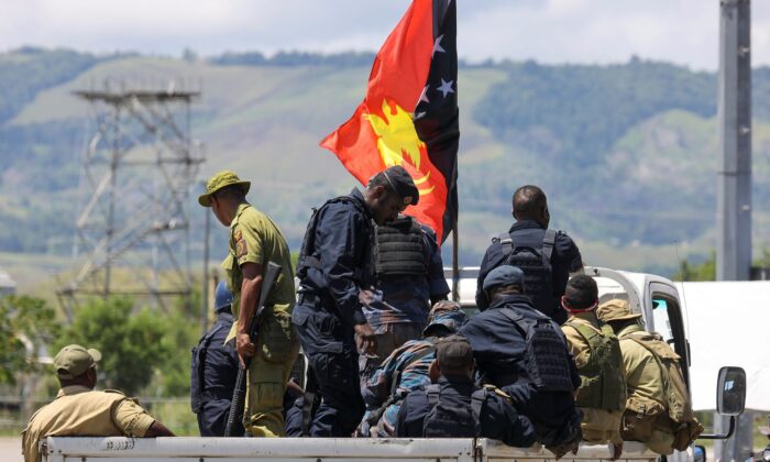 Papua New Guinea police arrive at the airport in Honiara, Solomon Islands, on Nov. 27, 2021. (Gary Ramage via AP)