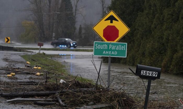 Debris is pictured along a flooded road in Abbotsford, B.C., November 25, 2021. (The Canadian Press/Jonathan Hayward)