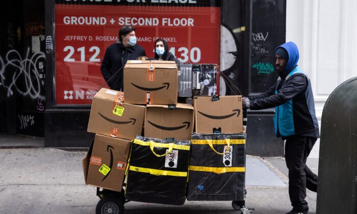 A delivery person pushes a cart full of Amazon boxes during Black Friday sales in the Manhattan borough of New York City, N.Y., on Nov. 26, 2021. (Jeenah Moon/Reuters)