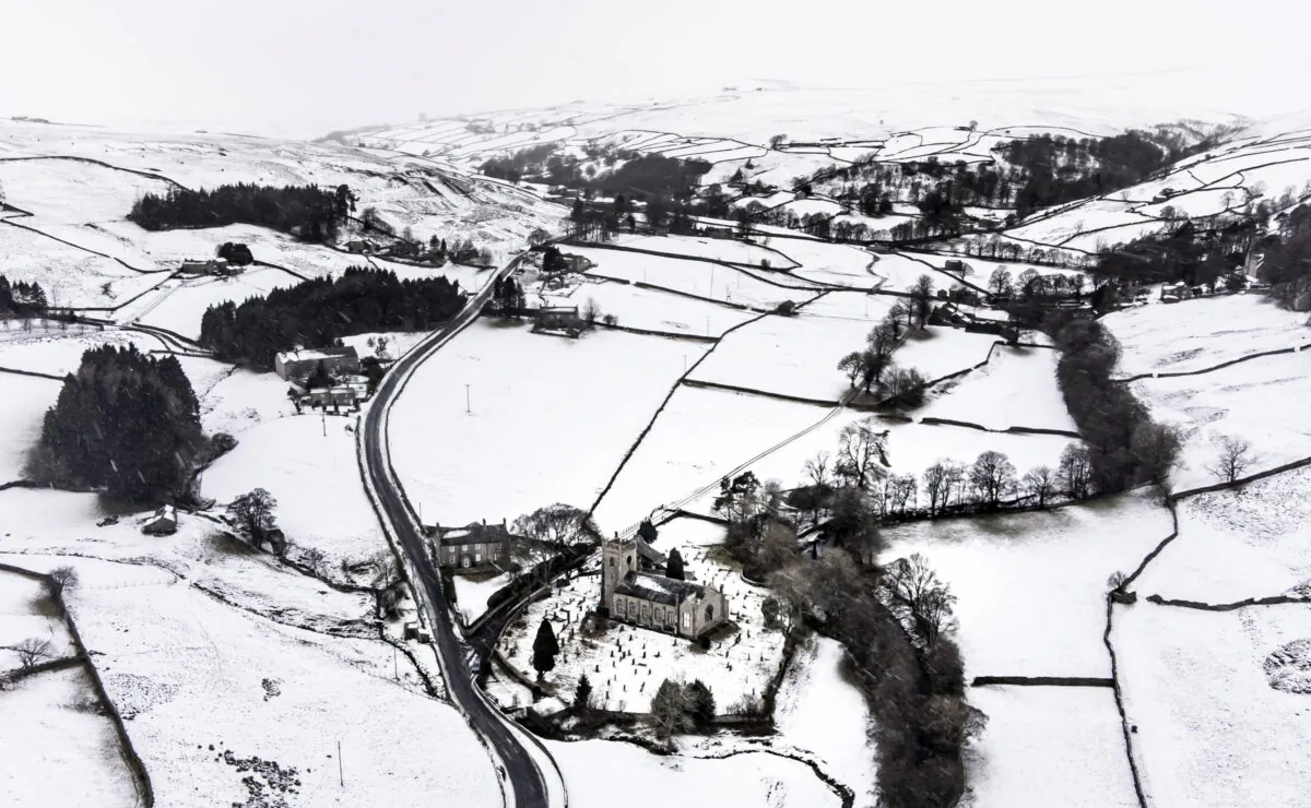 Snow covers fields and hills surrounding St, Mary The Virgin Church in the Arkengarthdale, North Yorkshire, amid freezing conditions in the aftermath of Storm Arwen, on Nov. 28, 2021. (Danny Lawson/PA via AP)