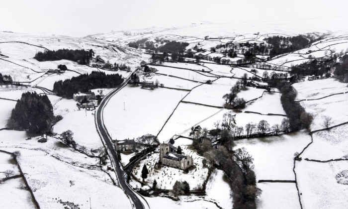 Snow covers fields and hills surrounding St. Mary The Virgin Church in the Arkengarthdale, North Yorkshire, amid freezing conditions in the aftermath of Storm Arwen, on Nov. 28, 2021. (Danny Lawson/PA via AP)