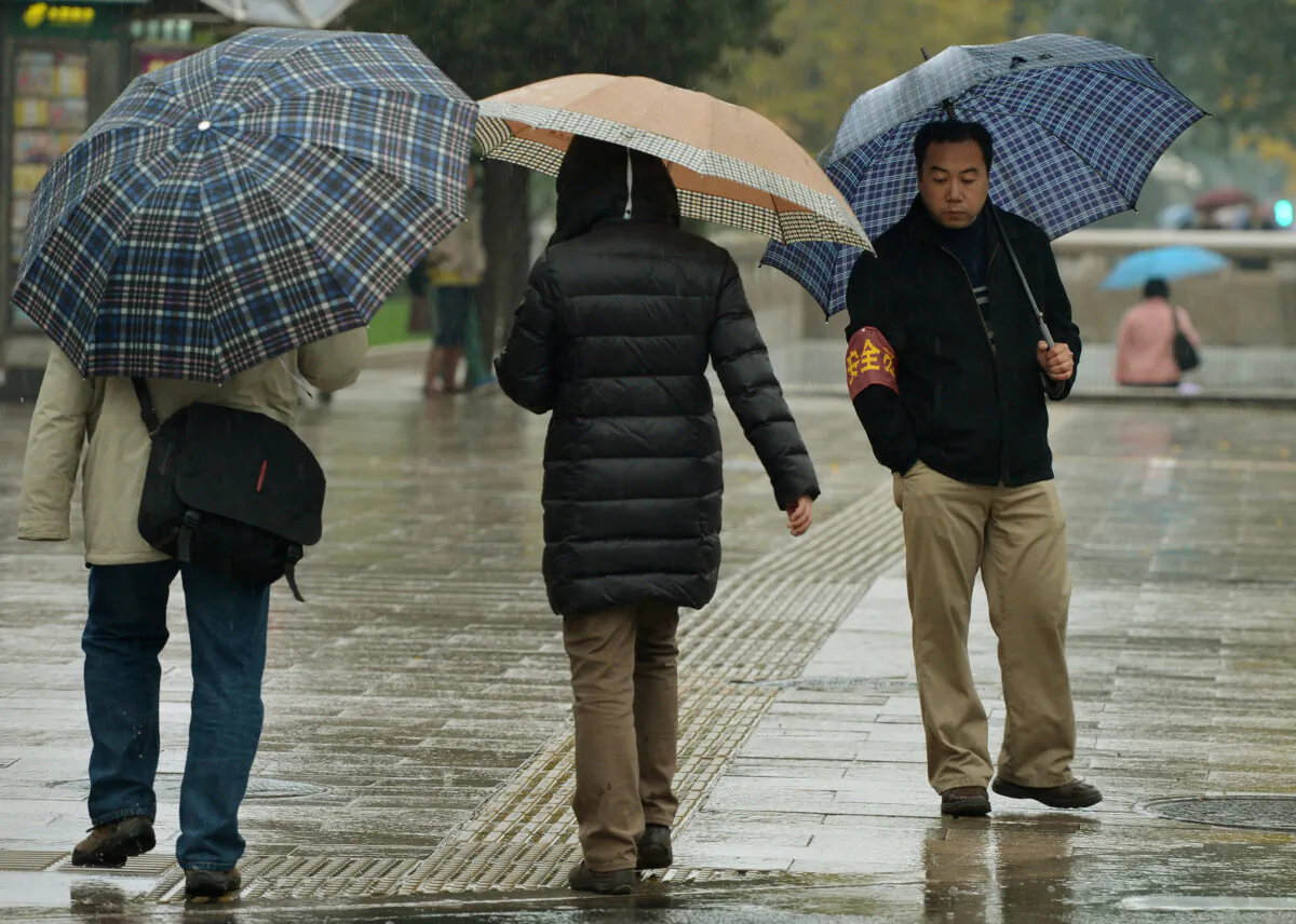 A security volunteer (R) keeps watch near the Great Hall of the People, which is the site of the Party Congress in Beijing on November 10, 2012. (Mark Ralston/AFP via Getty Images)