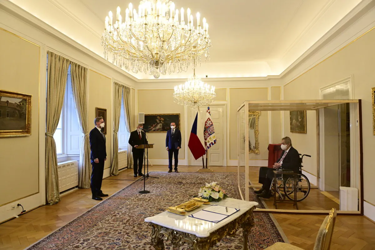 Czech President Milos Zeman, separated by a transparent wall after testing positive for COVID-19, appoints Civic Democratic Party (ODS) leader Petr Fiala as the new prime minister, at the Lany Chateau, near Prague, Czech Republic, on Nov. 28, 2021. (Roman Vondrous/Pool via Reuters)