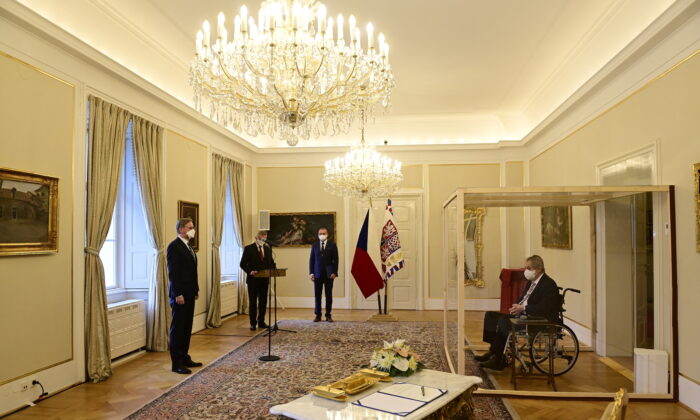 Czech President Milos Zeman, separated by a transparent wall after testing positive for COVID-19, appoints Civic Democratic Party (ODS) leader Petr Fiala as the new prime minister, at the Lany Chateau, near Prague, Czech Republic, on Nov. 28, 2021. (Roman Vondrous/Pool via Reuters)
