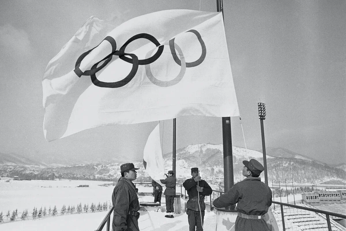 Members of Japan’s self defense ground forces raise Olympic Flags at Makomanai speed skating stadium in Sapporo, Japan, on Jan. 23, 1972, in a rehearsal of a ceremony to take place on Feb. 3 at the official opening of the Winter Olympics. (Mitsunori Chigita/AP Photo)