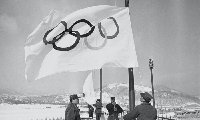 Members of Japan’s self defense ground forces raise Olympic Flags at Makomanai speed skating stadium in Sapporo, Japan, on Jan. 23, 1972, in a rehearsal of a ceremony to take place on Feb. 3 at the official opening of the Winter Olympics. (Mitsunori Chigita/AP Photo)