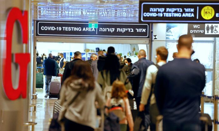 Passengers walk with their luggage upon their arrival at Ben Gurion Airport near Lod, Israel, on Nov. 1, 2021. (Jack Guez/AFP via Getty Images)