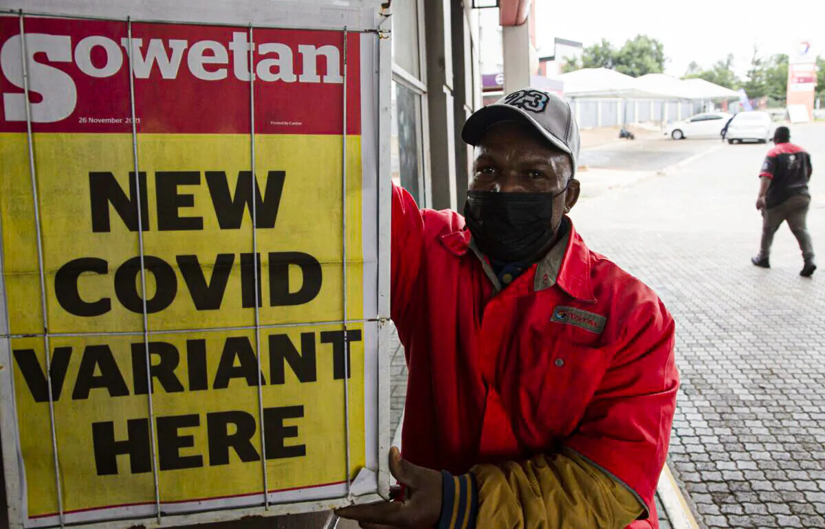 A petrol attendant stands next to a newspaper headline in Pretoria, South Africa, on Nov. 27, 2021. As the world grapples with the emergence of the new variant of COVID-19, scientists in South Africa—where Omicron was first identified—are scrambling to combat its spread across the country. (AP Photo/Denis Farrell)
