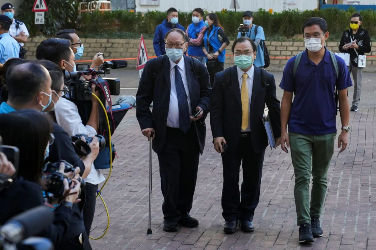 Sze Tak-Loy (R), one of the 47 pro-democracy activists charged with conspiracy to commit subversion, arrives at West Kowloon Magistrates' Courts building to take part in a hearing, in Hong Kong, on Nov. 29, 2021. (Lam Yik/Reuters)