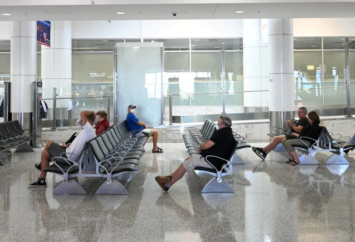 People sit in the arrivals section of the international terminal of Kingsford Smith International Airport in Sydney, Australia, on March 21, 2020. (Loren Elliott/Reuters)