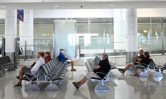 People sit in the arrivals section of the international terminal of Kingsford Smith International Airport in Sydney, Australia, on March 21, 2020. (Loren Elliott/Reuters)