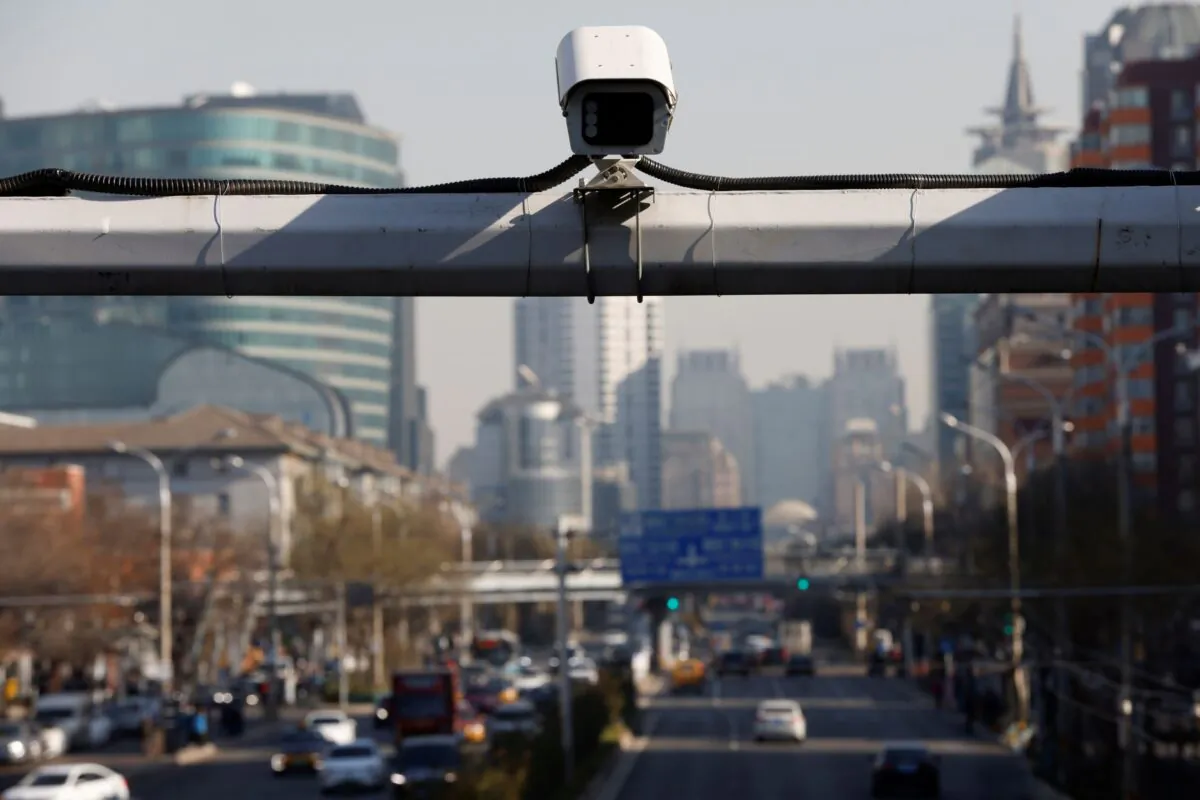 A security surveillance camera overlooks a street as cars drive by in Beijing, China on Nov. 24, 2021. (Carlos Garcia Rawlins/Reuters)