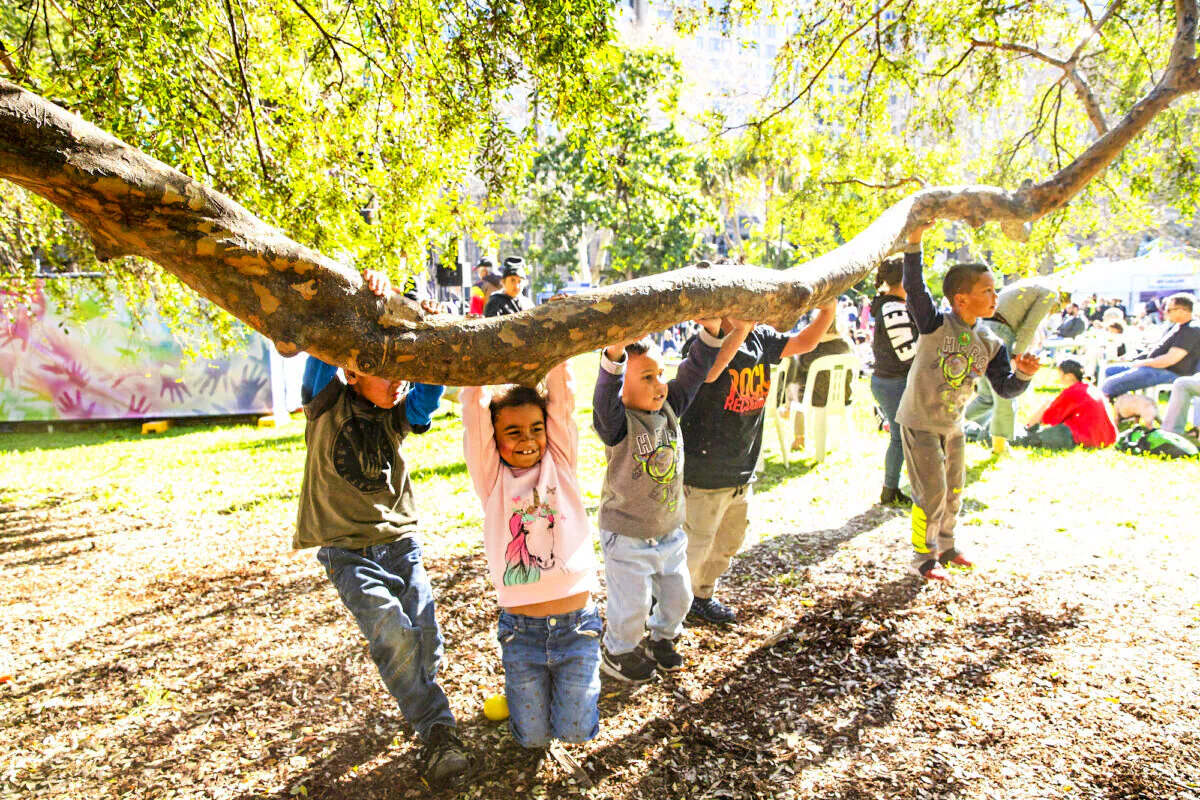 Children play on the branch of a tree at Hyde Park in Sydney, Australia, on July 13, 2019. (Jenny Evans/Getty Images)