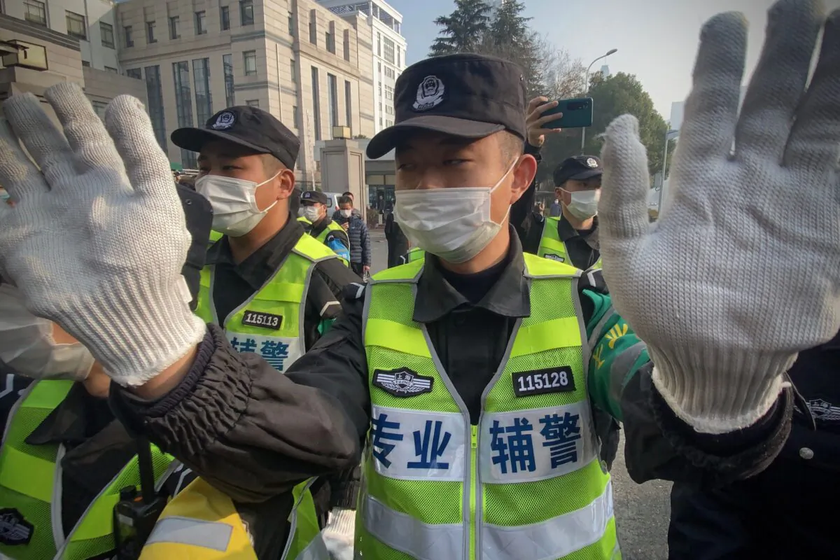 Police attempt to stop journalists from recording footage outside the Shanghai Pudong New District People's Court, where Chinese citizen journalist Zhang Zhan is set for trial in Shanghai on Dec. 28, 2020. (Leo Ramirez/AFP via Getty Images)