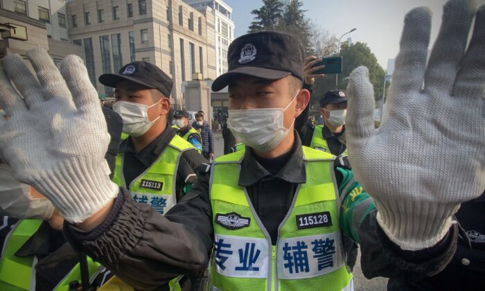 Police attempt to stop journalists from recording footage outside the Shanghai Pudong New District People's Court, where Chinese citizen journalist Zhang Zhan is set for trial in Shanghai on Dec. 28, 2020. (Leo Ramirez/AFP via Getty Images)
