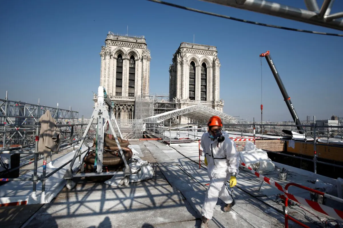 A worker walks on the roof of the Notre-Dame de Paris Cathedral two years after the blaze that made the spire collapse and destroyed much of the roof, in Paris on April 15, 2021. (Benoit Tessier/POOL/AFP via Getty Images)
