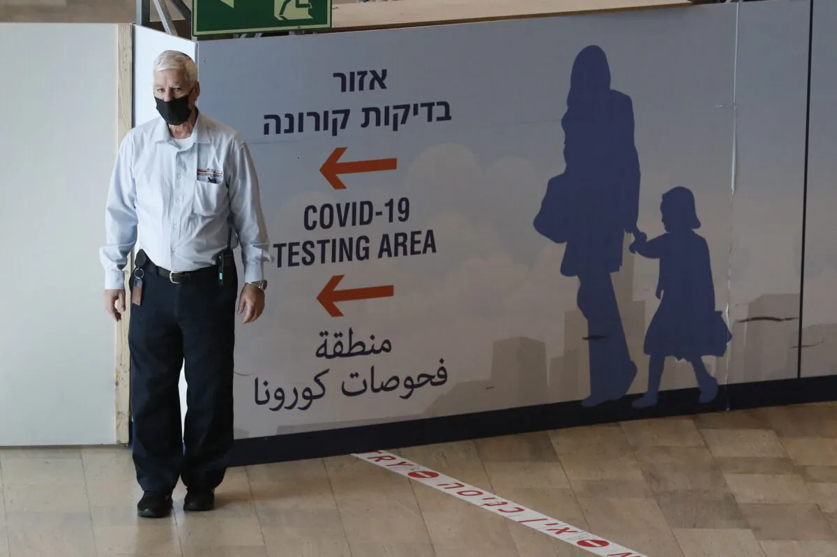 A staff member assists arriving passengers at Israel's Ben Gurion Airport in Lod, east of Tel Aviv, on Nov. 28, 2021. (Ahmad Gharabli/AFP via Getty Images)