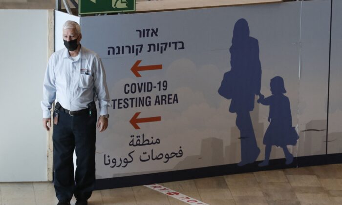 A staff member assists arriving passengers at Israel's Ben Gurion Airport in Lod, east of Tel Aviv, on Nov. 28, 2021. (Ahmad Gharabli/AFP via Getty Images)