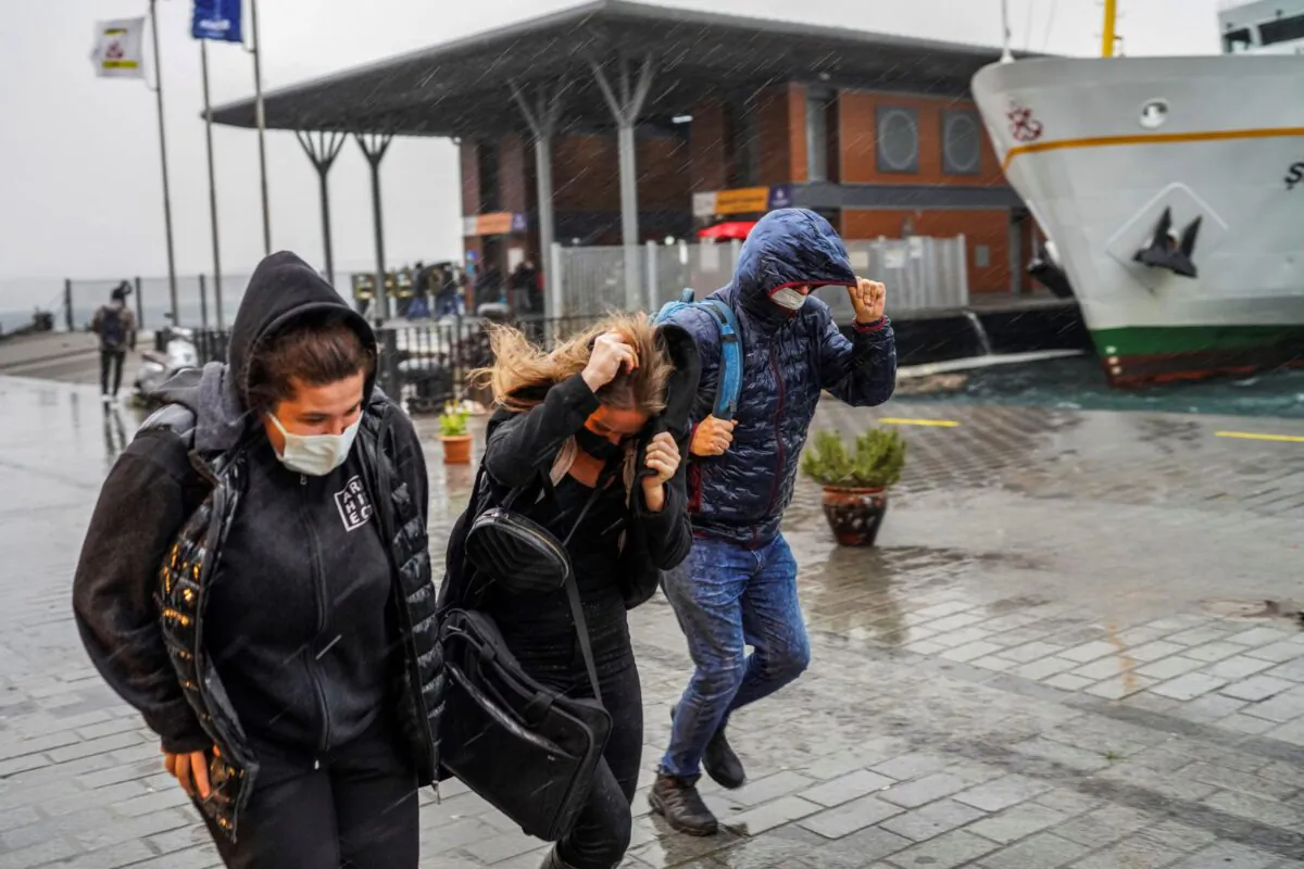 People run under a heavy rain during a stormy day in Istanbul, Turkey, on Nov. 29, 2021. (AP Photo)
