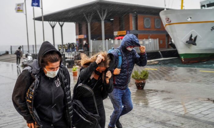 People run under a heavy rain during a stormy day in Istanbul, Turkey, on Nov. 29, 2021. (AP Photo)