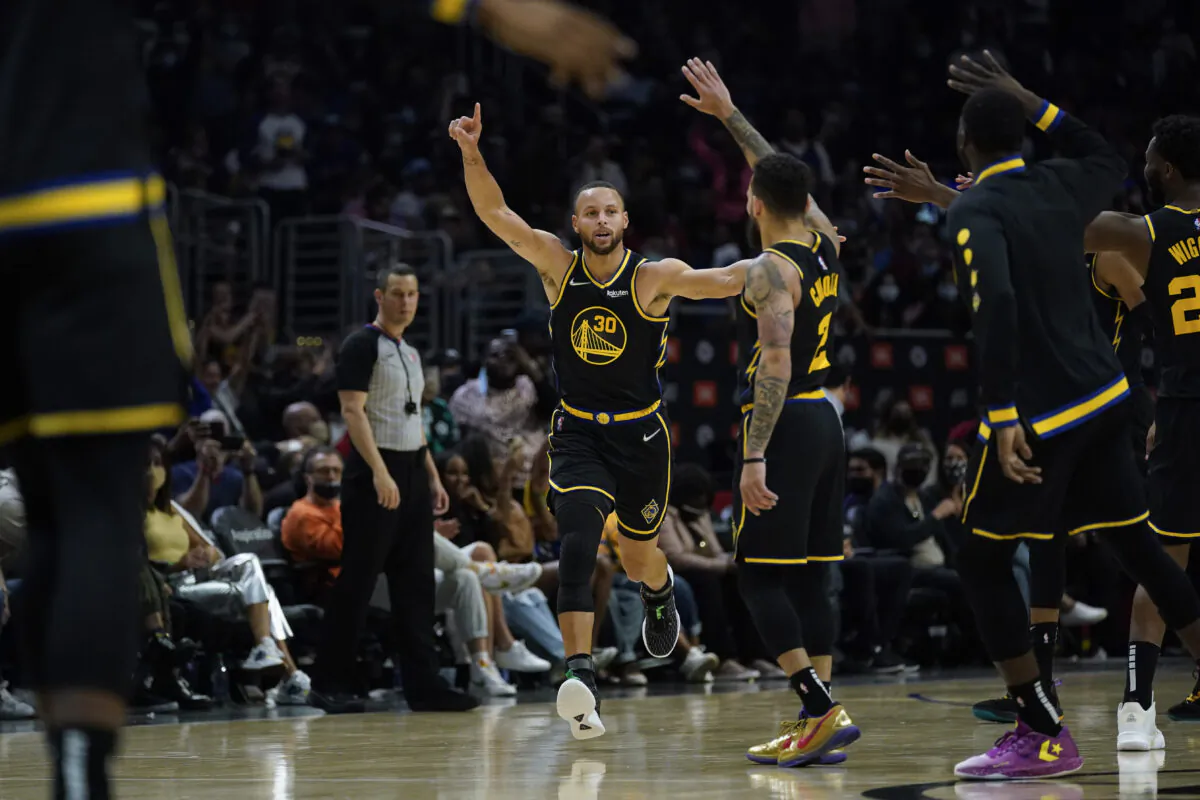 Golden State Warriors guard Stephen Curry (30) celebrates after making a three-pointer during the second half of an NBA basketball game in Los Angeles on Nov. 28, 2021. (AP Photo/Ashley Landis)