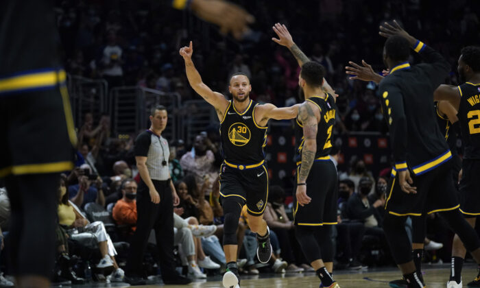 Golden State Warriors guard Stephen Curry (30) celebrates after making a three-pointer during the second half of an NBA basketball game in Los Angeles on Nov. 28, 2021. (AP Photo/Ashley Landis)