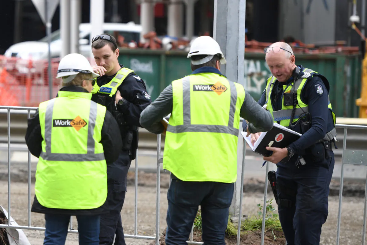 WorkSafe officers talk to police at the scene of a construction site accident in Southbank, Melbourne on Oct. 19, 2019. (AAP Image/Erik Anderson)