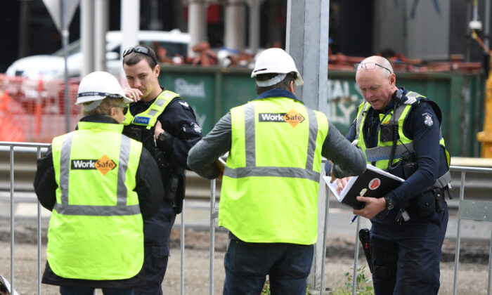 WorkSafe officers talk to police at the scene of a construction site accident in Southbank, Melbourne on Oct. 19, 2019. (AAP Image/Erik Anderson)